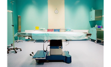 An operating table in the middle of an empty operating room within a hospital
