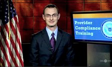 Tony Maida stands in front of a screen that says "Provider Compliance Training" and an American flag