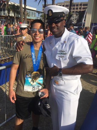 Bautista (left) standing at Never Quit 5K with a service member in uniform (right).