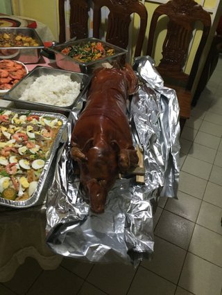 Lechon (roasted pig) on the Bautista family's dinner table, next to other Filipino dishes.