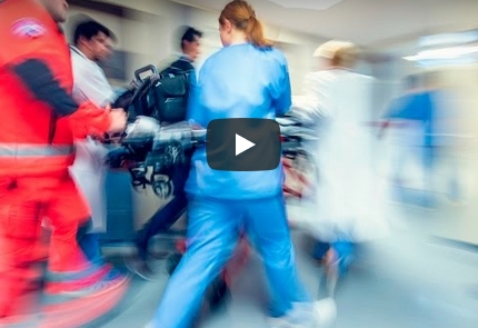 A scene of people rushing through a hospital corridor with a patient